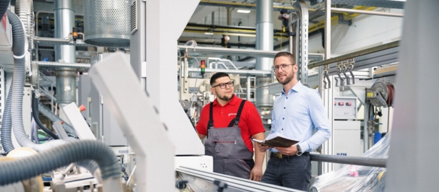 Mitarbeitende an der Maschine gewährleisten reibungslose Arbeitsabläufe.